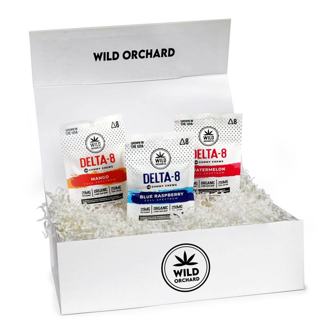 A white box labeled "wild orchard" containing a Variety 3-Pack Delta 8 Gummies in mango, blue raspberry, and watermelon flavors.